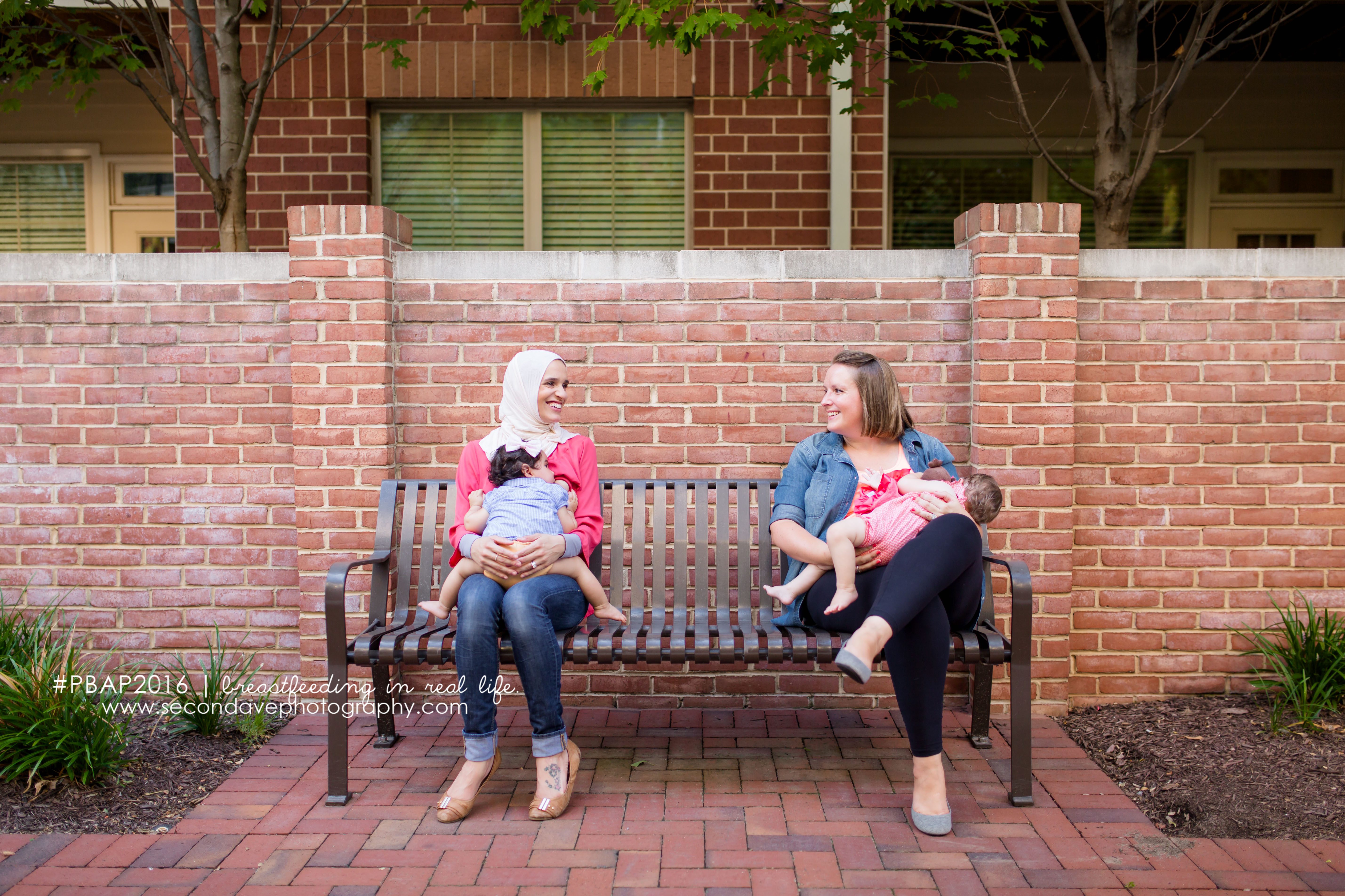 Portrait of two mothers of diverse ethnicities and religions breastfeeding together. “It is not our differences that divide us...