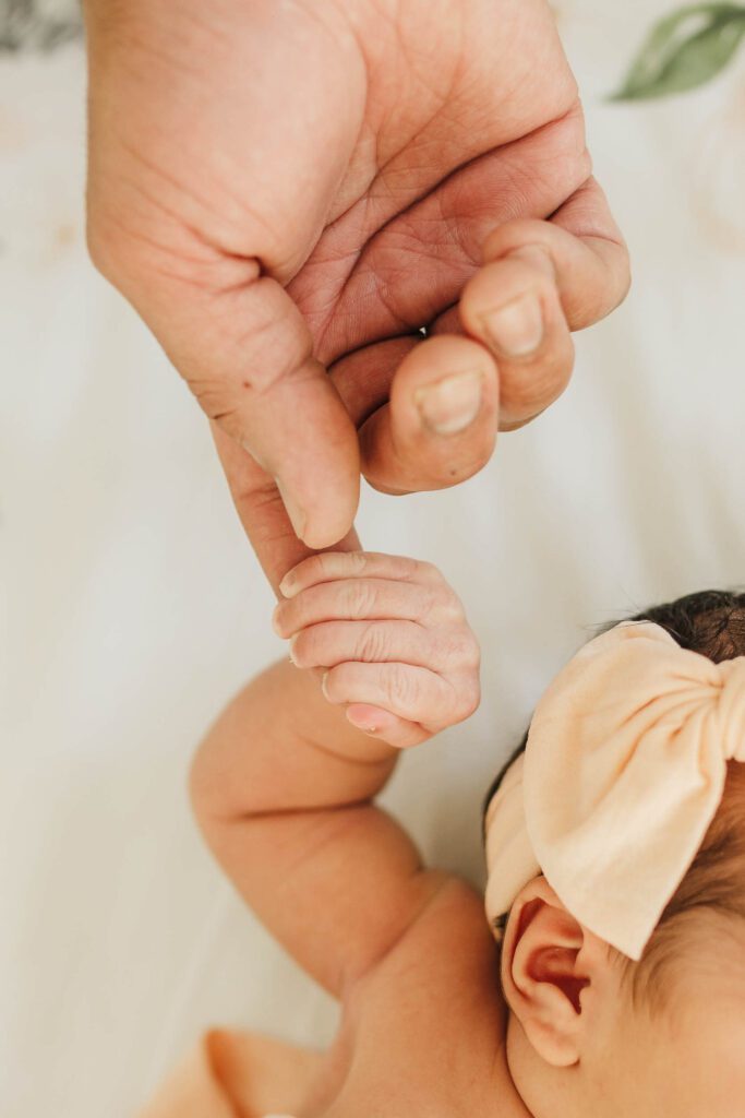 newborn-photo-fingers-curled-around-dads-close-up
