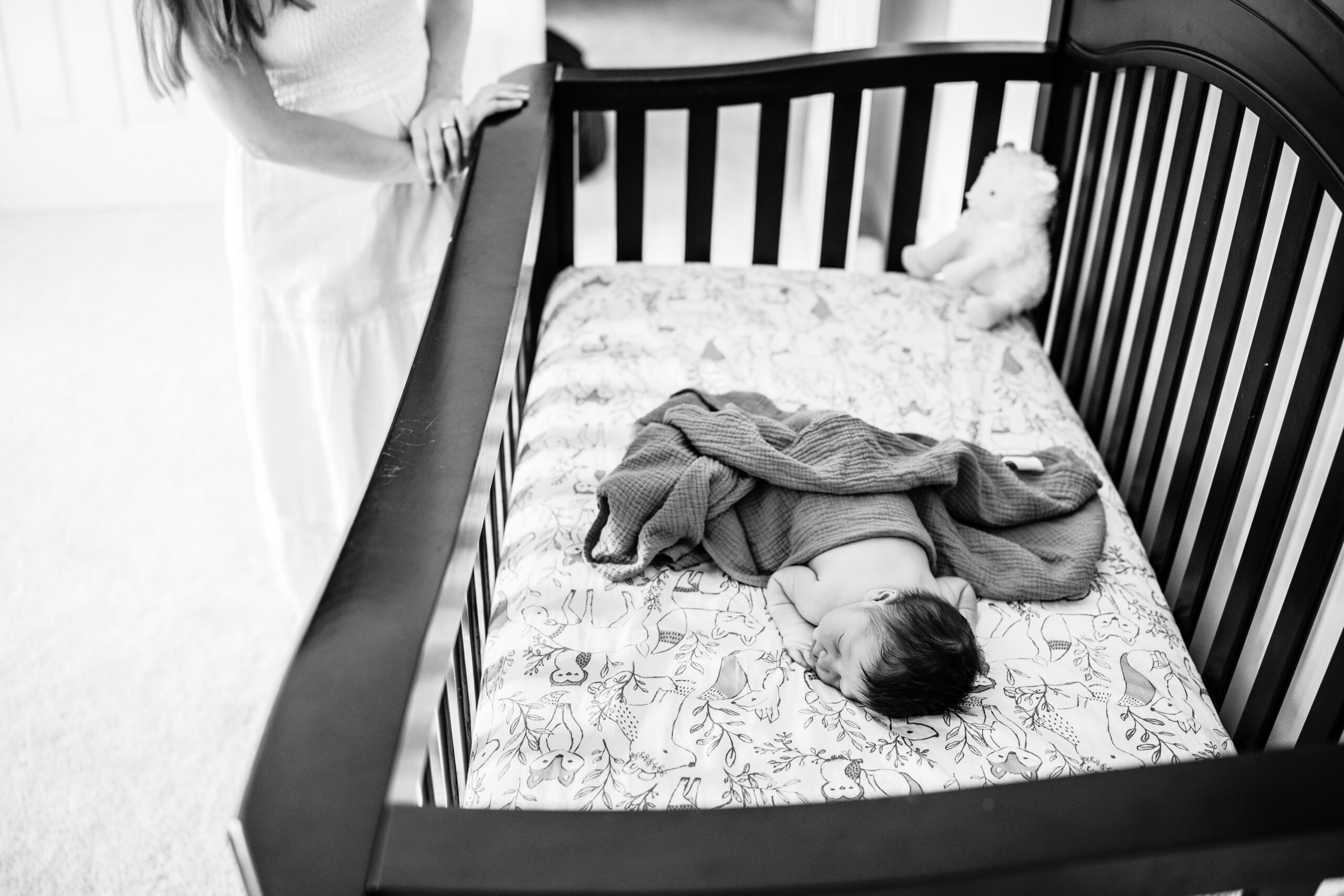 washington-dc-newborn-photography-mom-looking-baby-crib-black-and-white