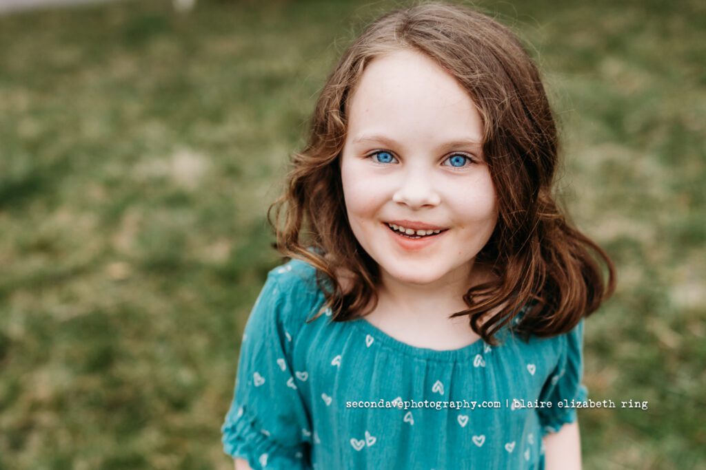 Smiling girl with extraordinarily bright blue eyes.