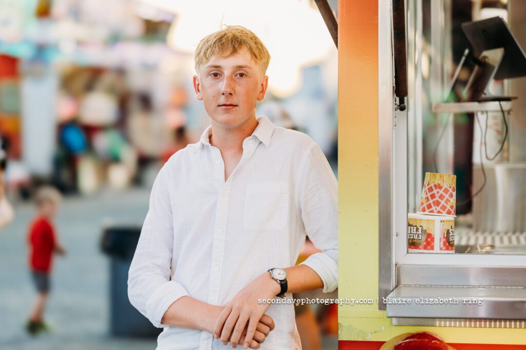 Senior photographer photographs high school senior at One Loudoun Carnival in Ashburn, Virginia.
